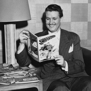 Bud Collyer reads a Superman comic book.